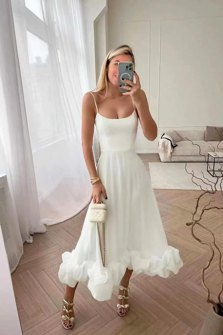 Model wearing a white ruffle hem midi dress with layered ruffle skirt