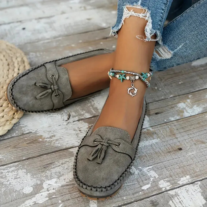 Gray suede loafer with tassel tie detail, front view