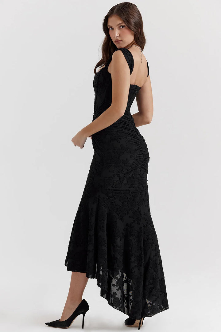 Model in a three-quarter turn wearing a pink lace mermaid gown with a trailing skirt