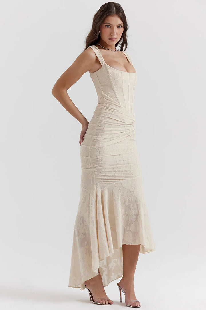 Model in a pink lace mermaid gown posed to highlight the structured bodice and skirt flare