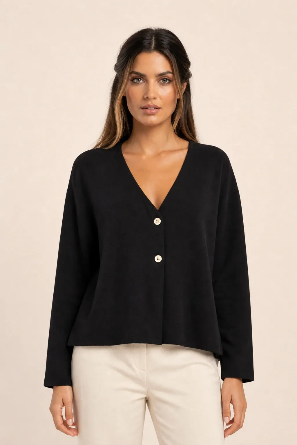 Black button-front knit cardigan on model in contrapposto stance