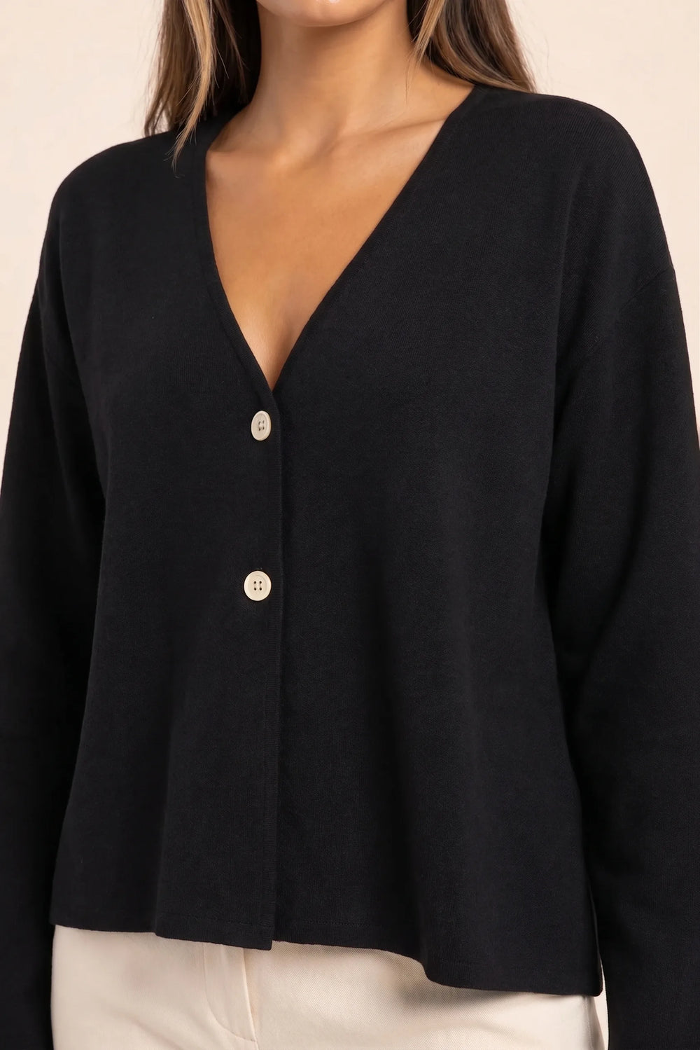 Close-up detail of black button-front knit cardigan buttons and texture