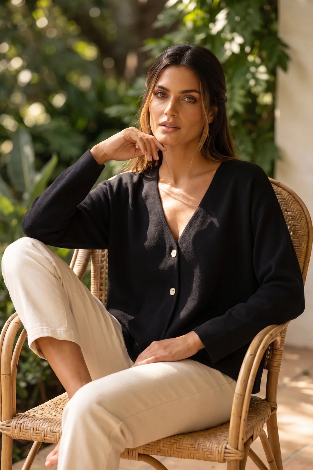 Model wearing black button-front knit cardigan in a casual lifestyle scene