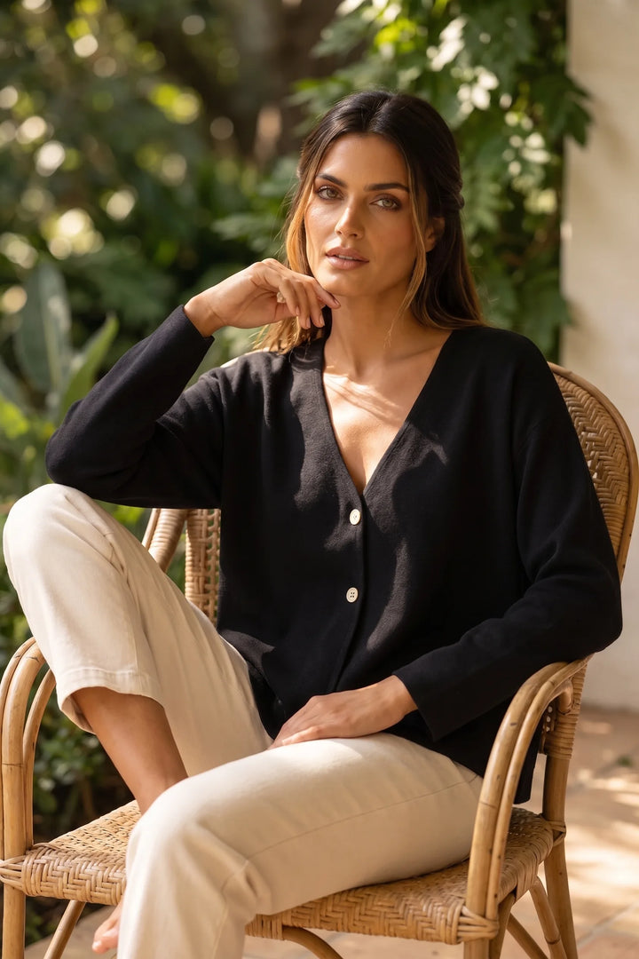 Model wearing black button-front knit cardigan in a casual lifestyle scene