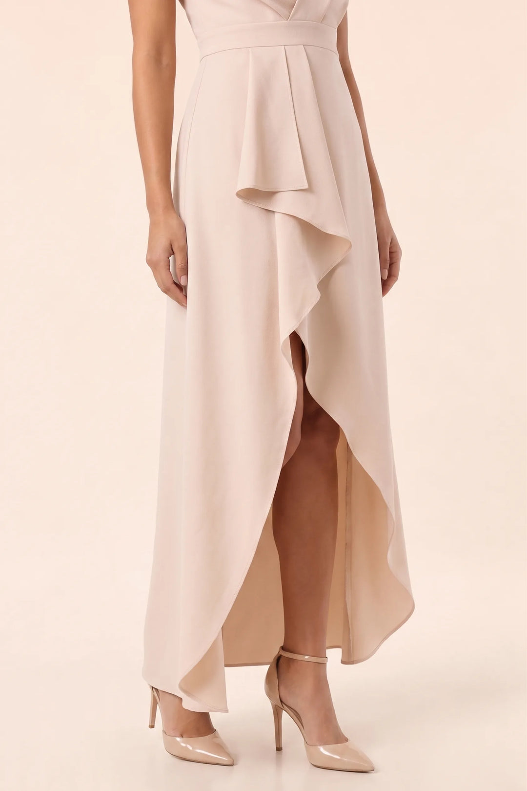 Close-up detail of ruffled hem and fabric on a beige high-low midi dress