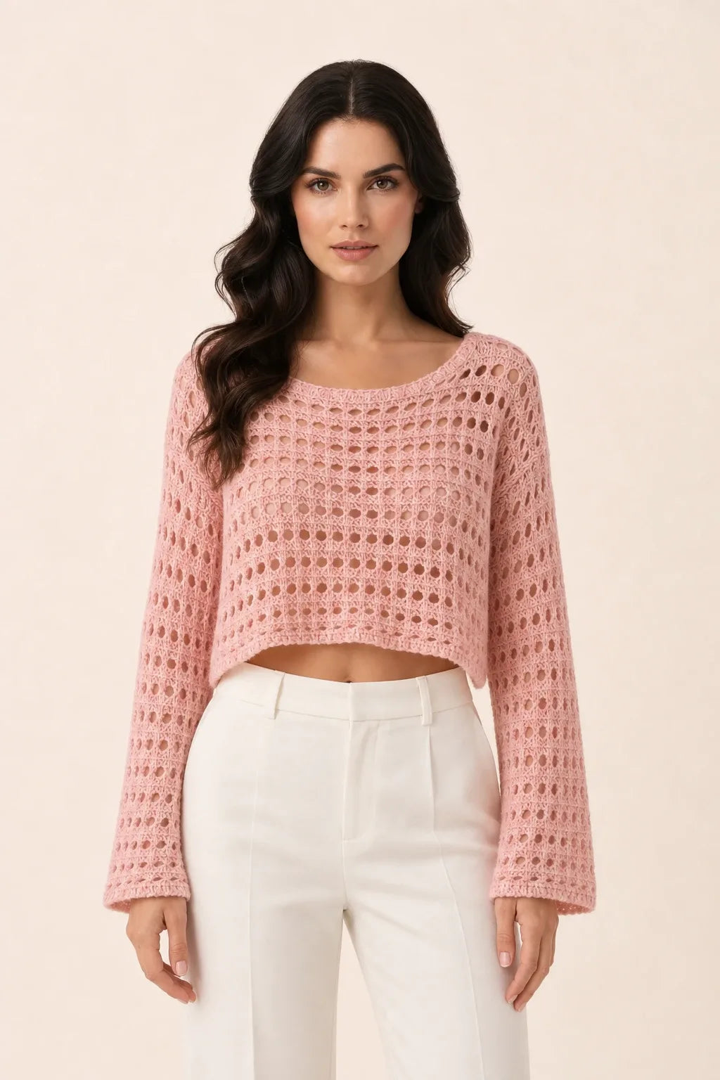 Pink open knit crop top on model in contrapposto stance