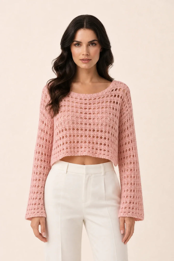 Pink open knit crop top on model in contrapposto stance