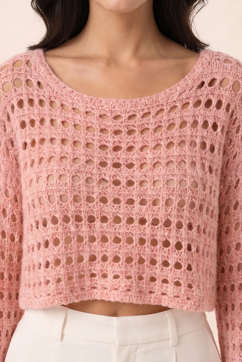 Close-up detail of pink open knit crop top texture and construction