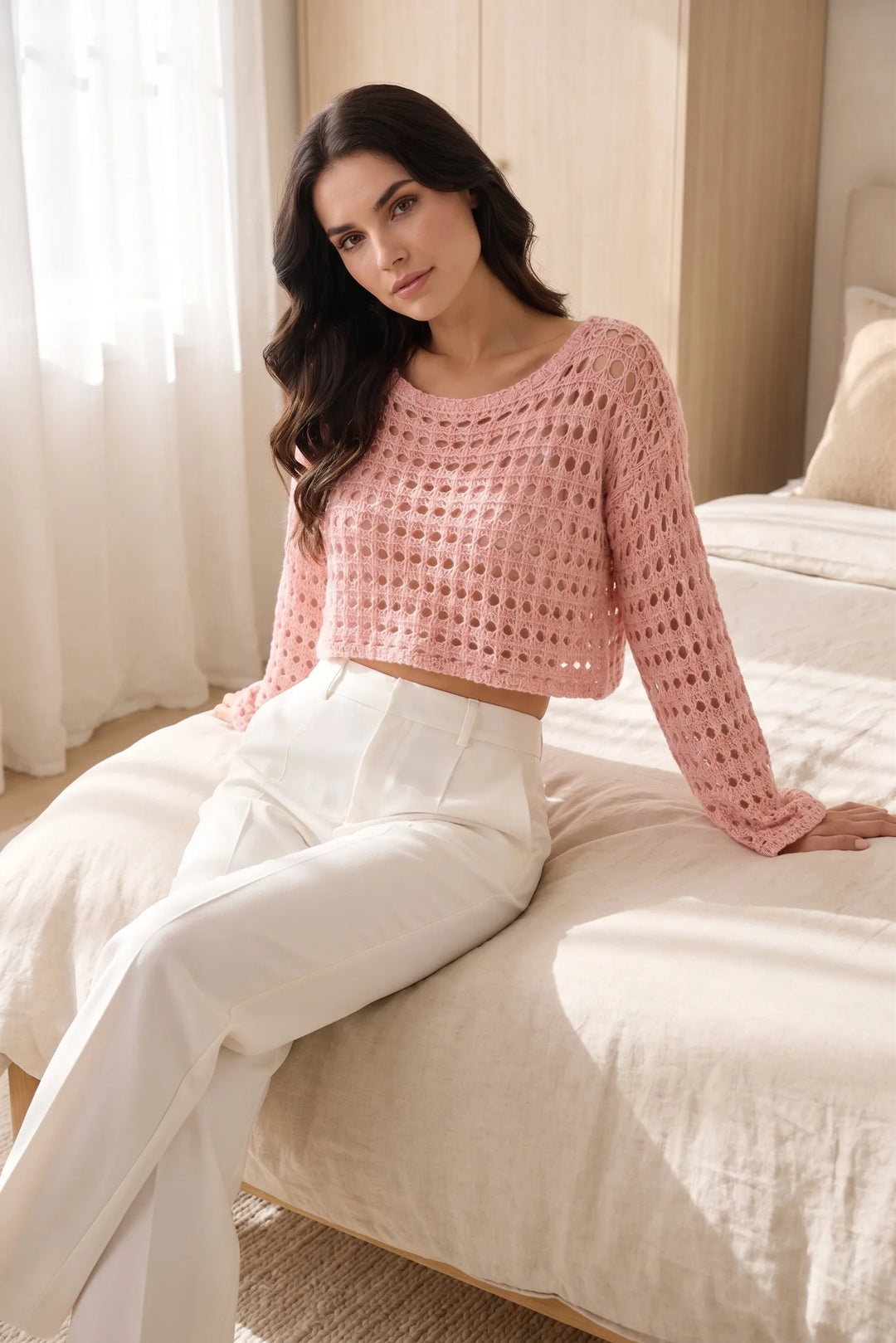Model wearing pink open knit crop top in a casual lifestyle setting