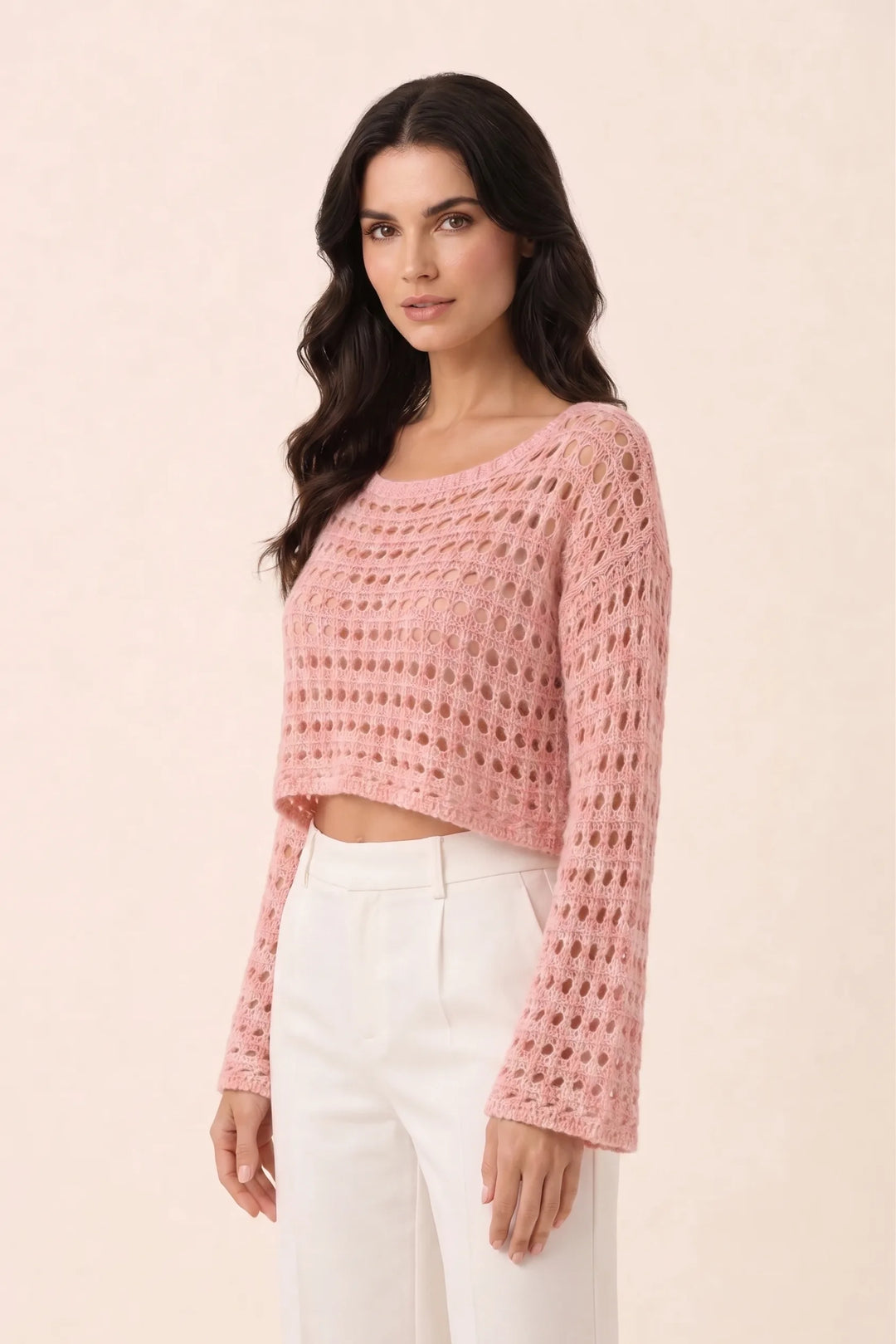 Pink open knit crop top on model in three-quarter turn