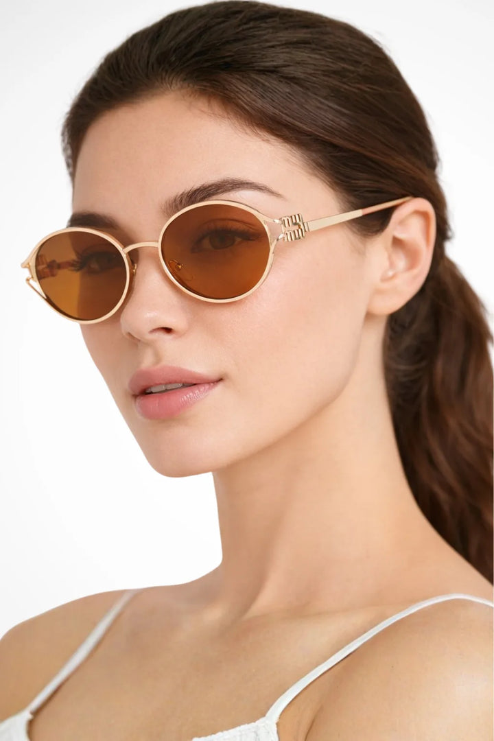 Slim oval metal eyeglass frames in tea and gold tones, front view