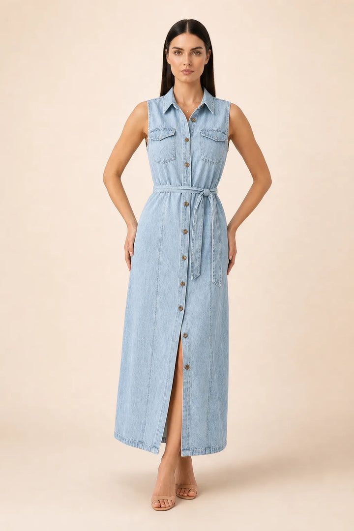 Woman in a belted blue denim maxi dress standing in a contrapposto pose