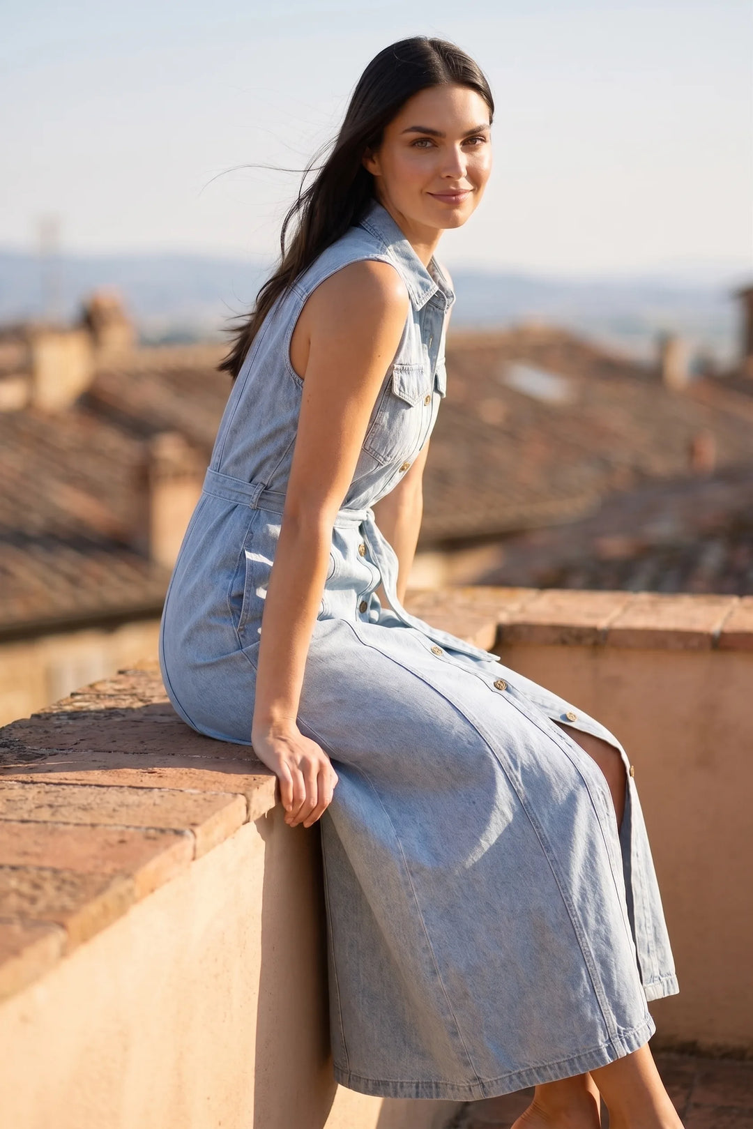 Woman wearing a belted blue denim maxi dress in an outdoor lifestyle setting