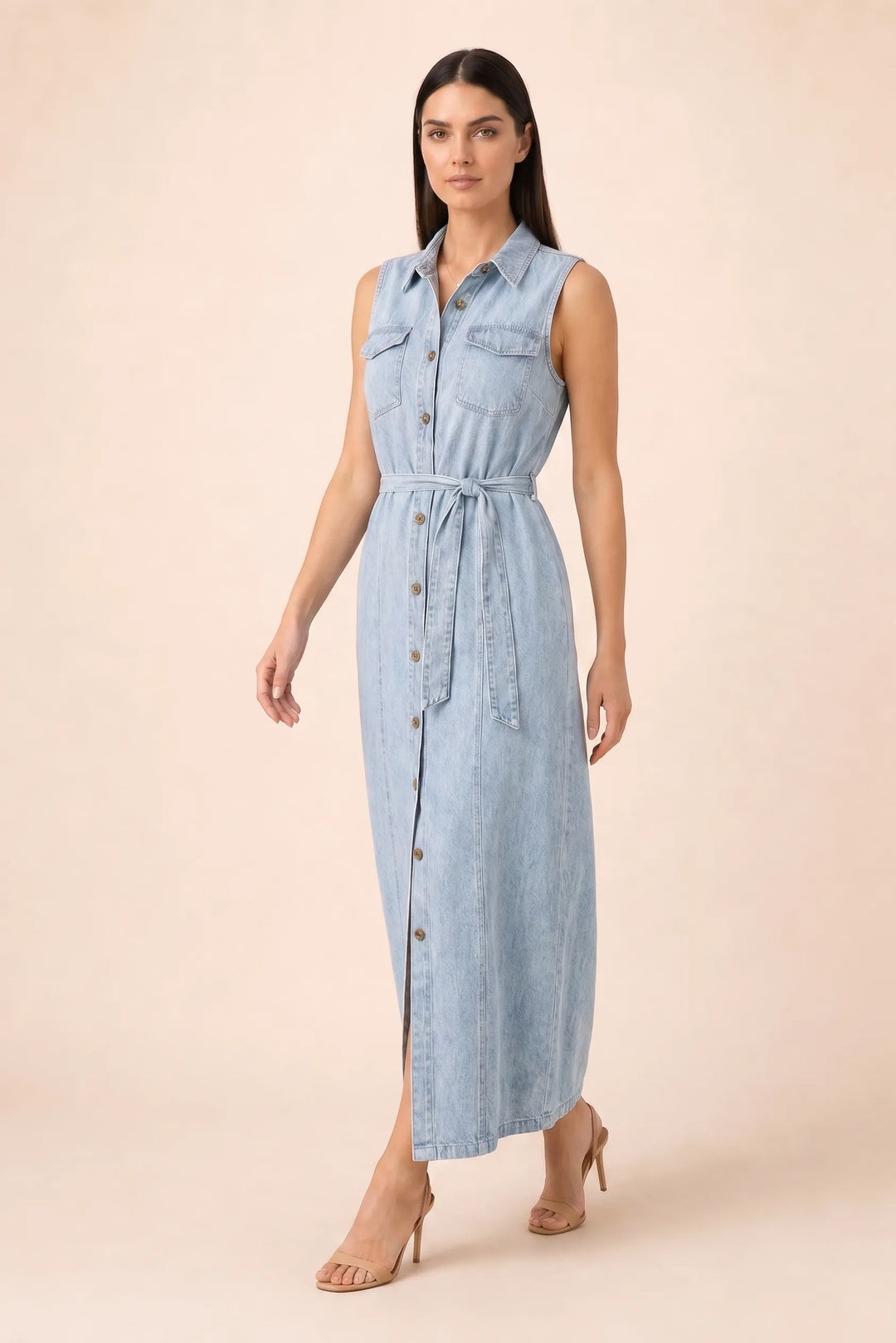 Woman in a belted blue denim maxi dress in a three-quarter turn
