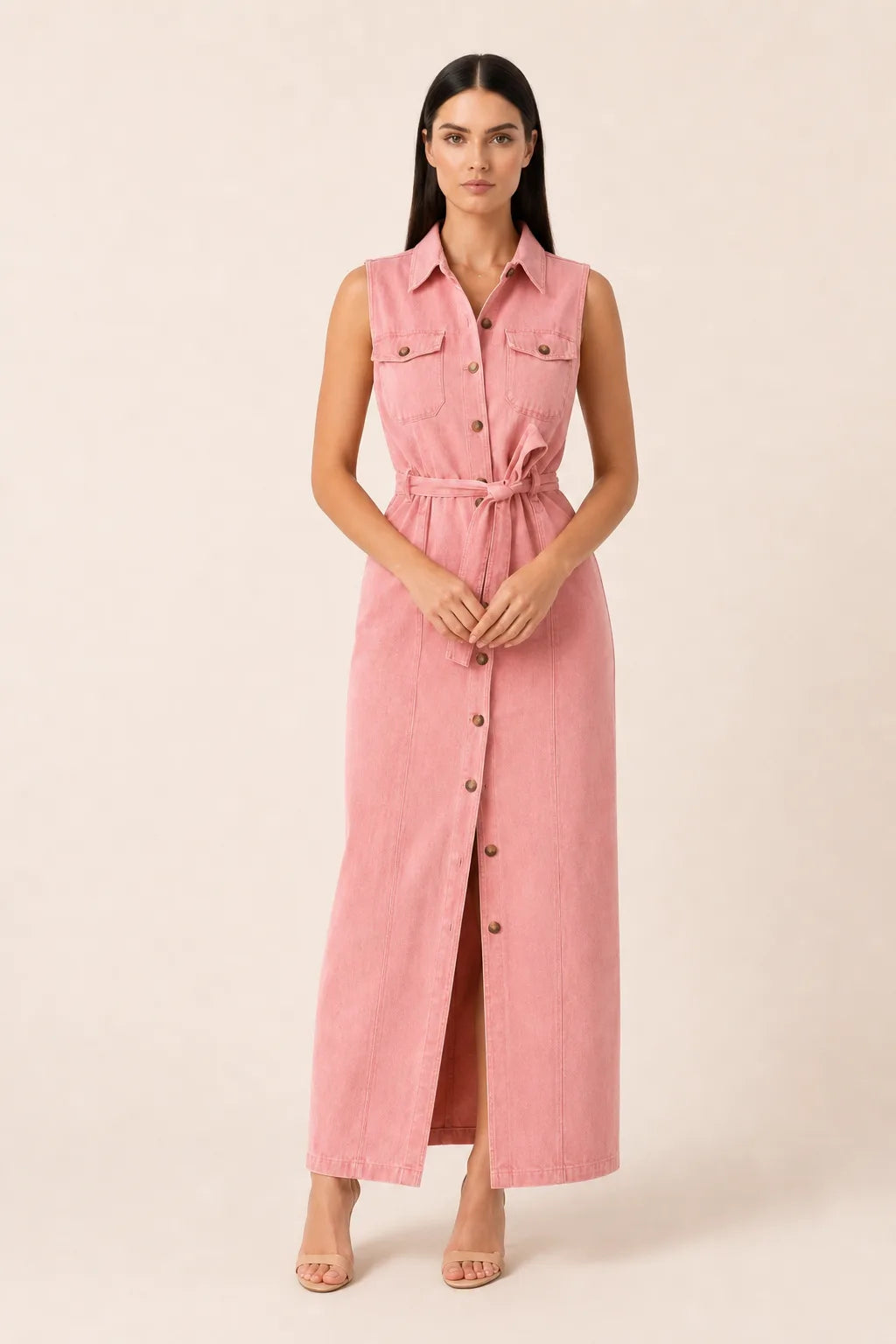 Woman in a belted pink denim maxi dress standing in a contrapposto pose