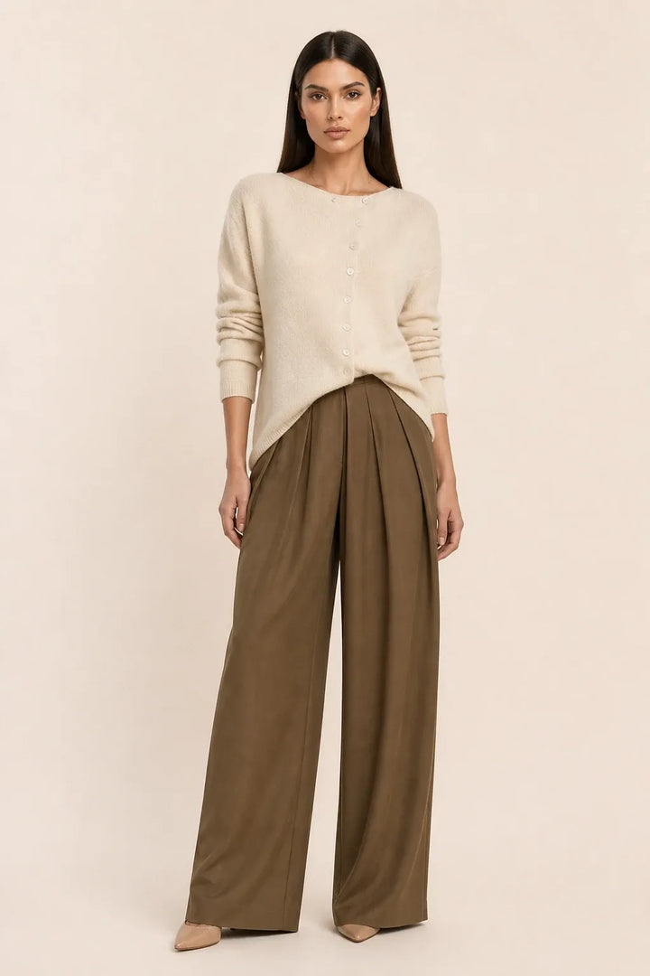 Beige asymmetric button cardigan on a model in a contrapposto stance