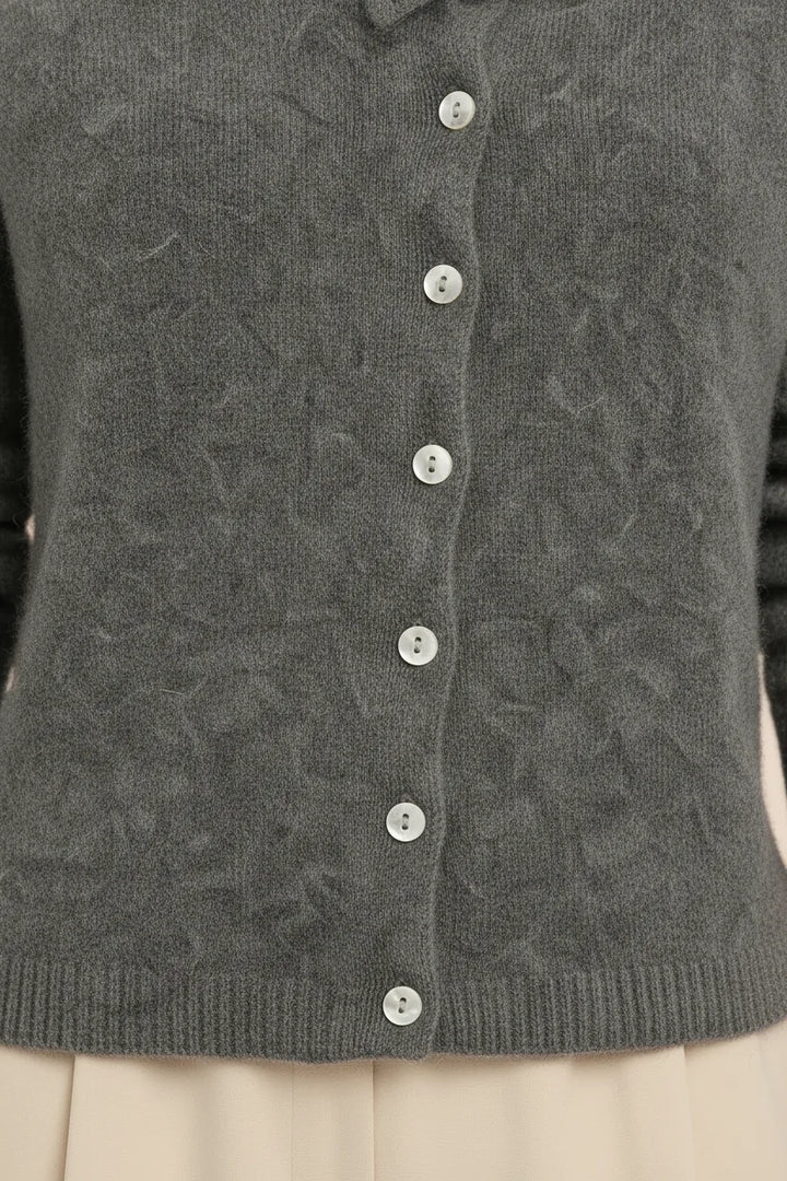 Close-up detail of a gray asymmetric button cardigan