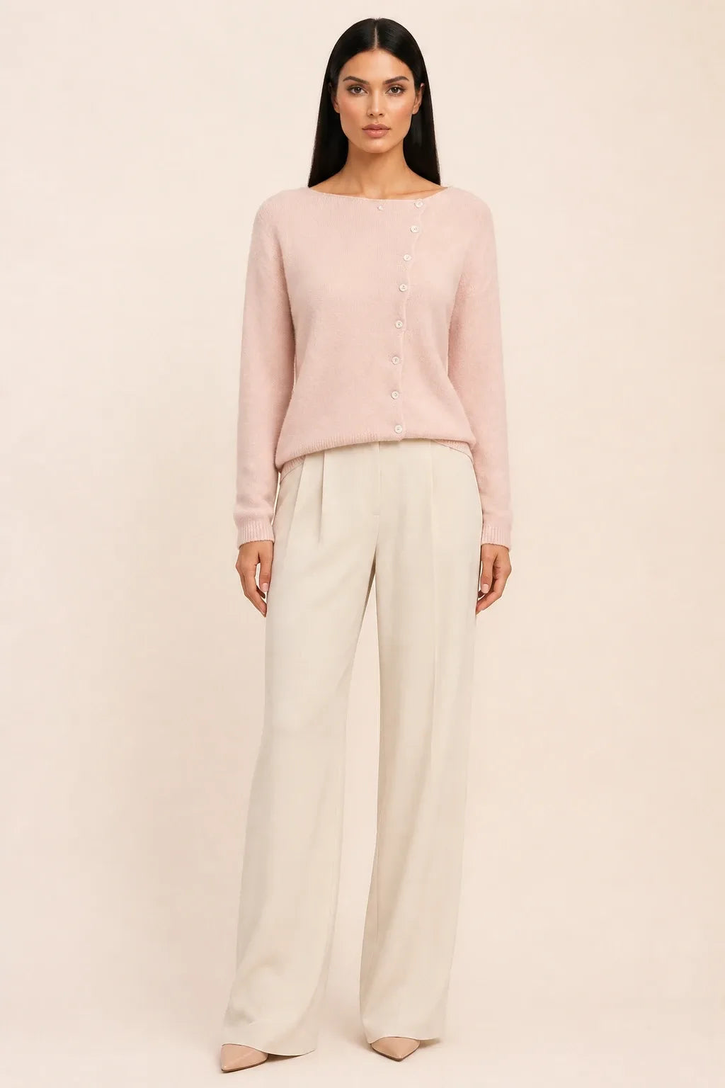 Pink asymmetric button cardigan on a model in a contrapposto stance