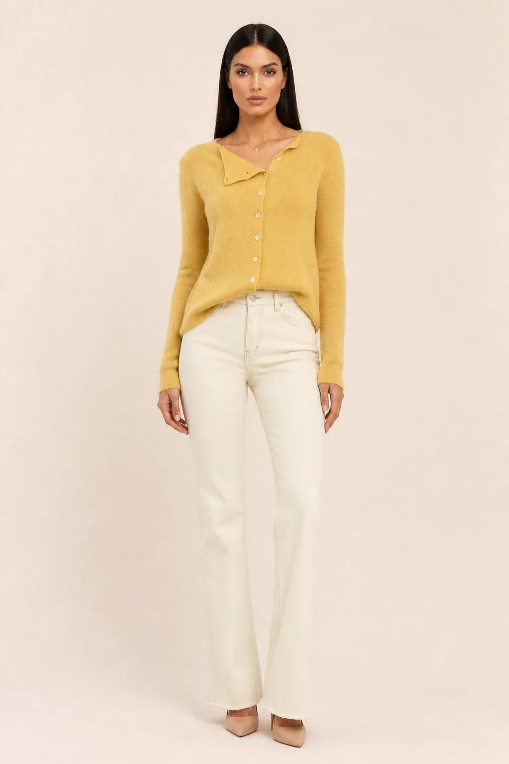 Yellow asymmetric button cardigan on a model in a contrapposto stance