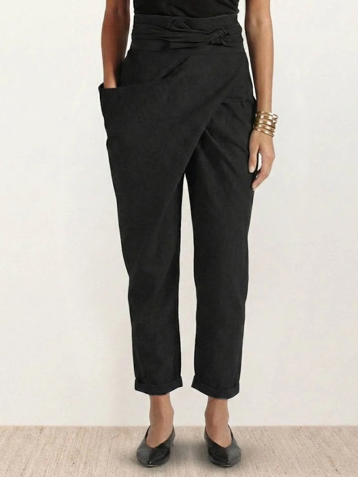Black wrap front tapered pants on model, full-length view