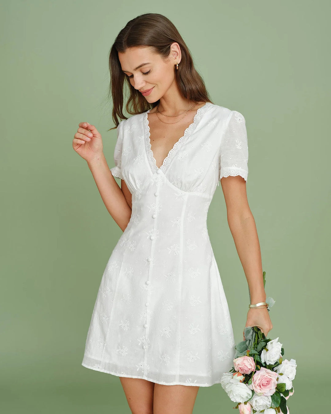 White eyelet mini skirt with button front, model at three-quarter turn