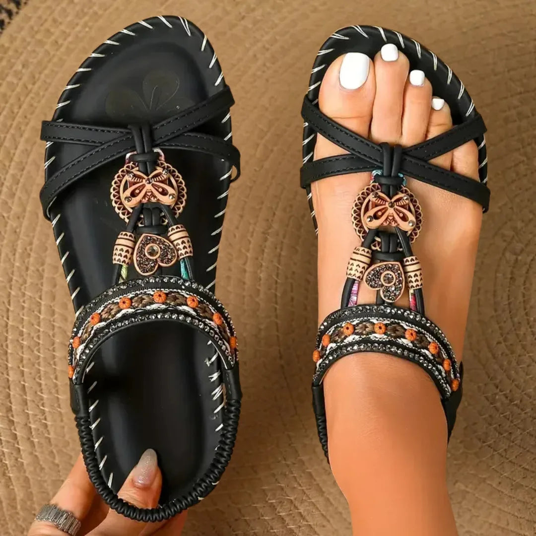 Black beaded flat sandal with boho detailing, three-quarter view