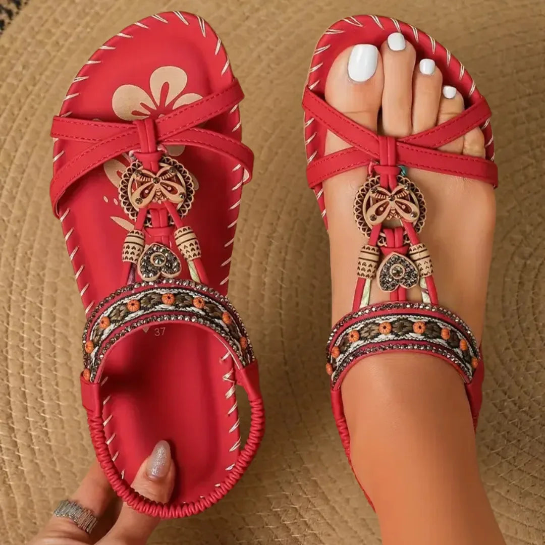 Red beaded flat sandal with boho detailing, side profile view