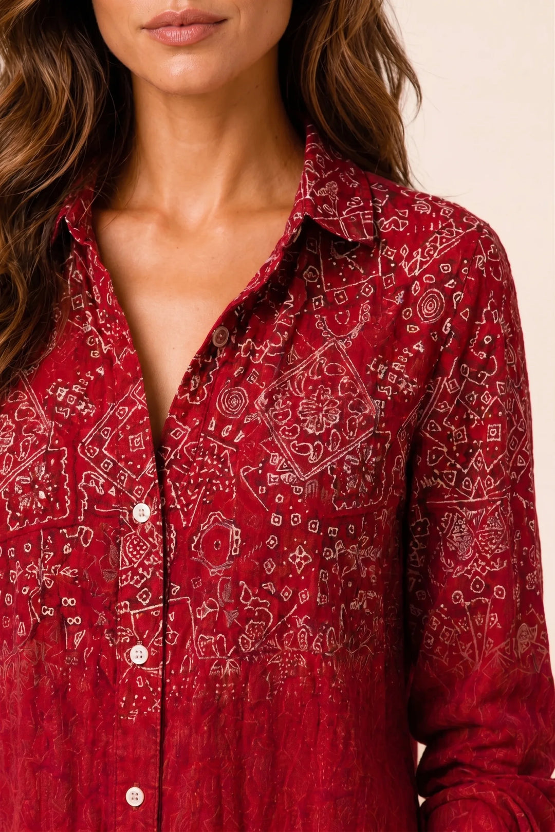 Close-up detail of red bandana print button-down blouse fabric and buttons