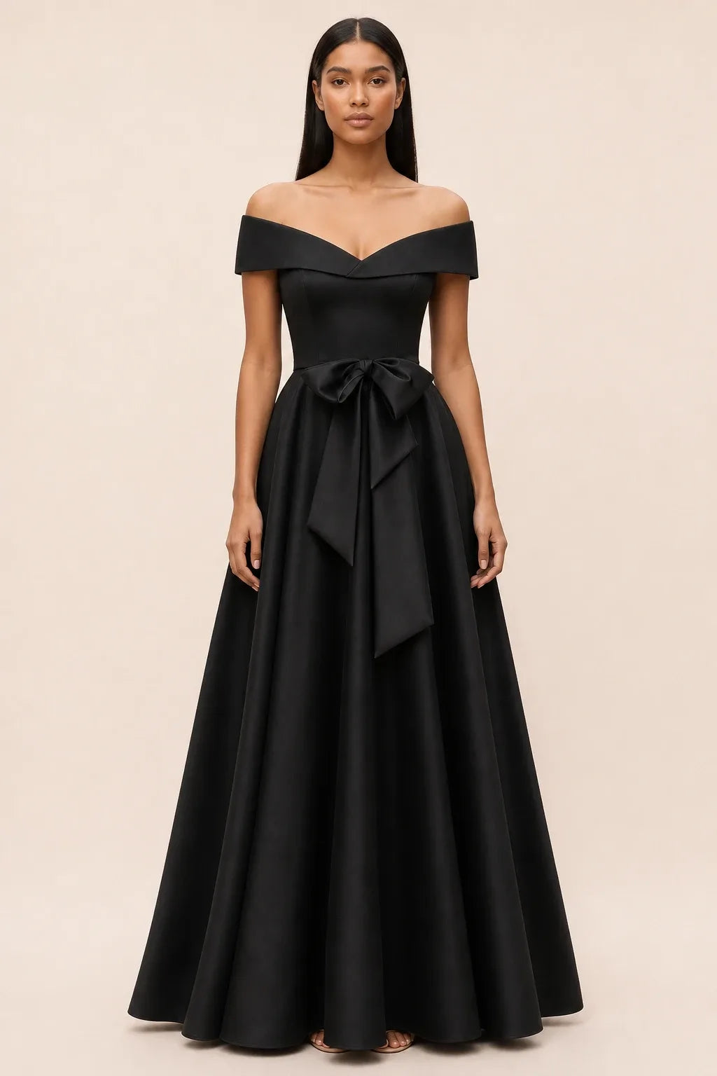 Black off-shoulder midi dress with bow detail, model in contrapposto stance