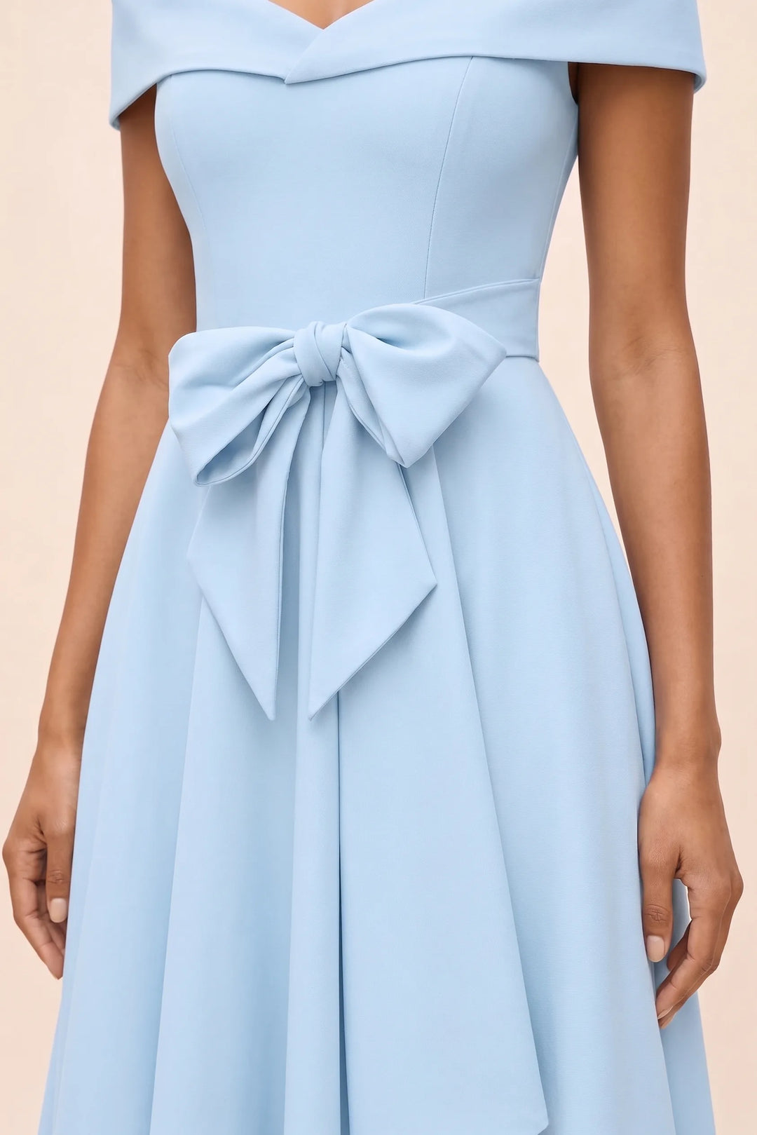 Close-up detail of bow on light blue off-shoulder midi dress