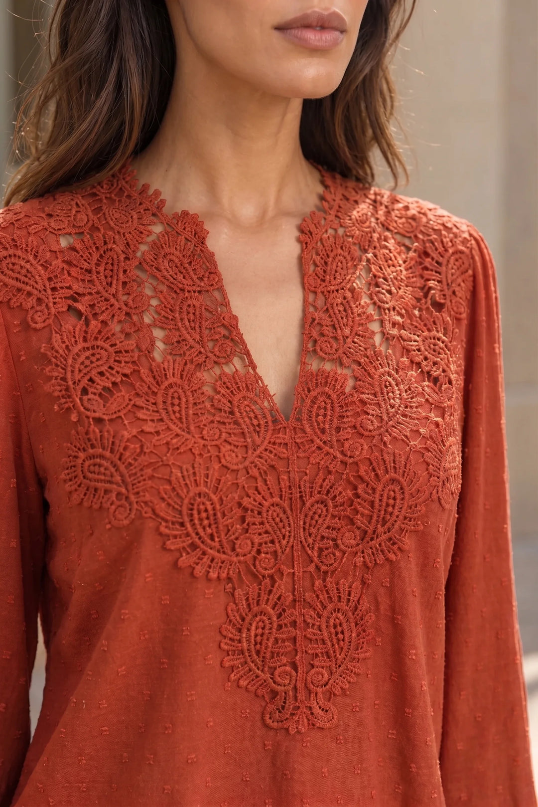 Close-up detail of red lace panel blouse fabric and panels