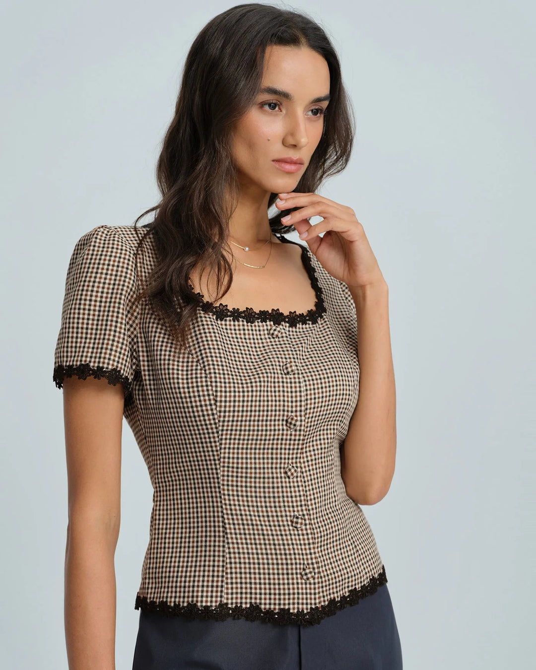 Close-up of lace trim detail on brown gingham fabric