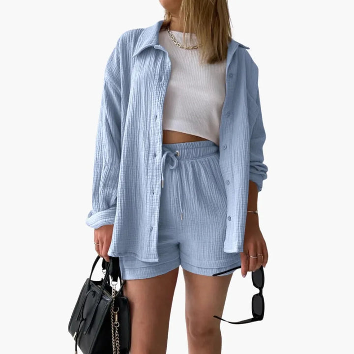 Model wearing a light blue crinkle button-up shirt and matching shorts set