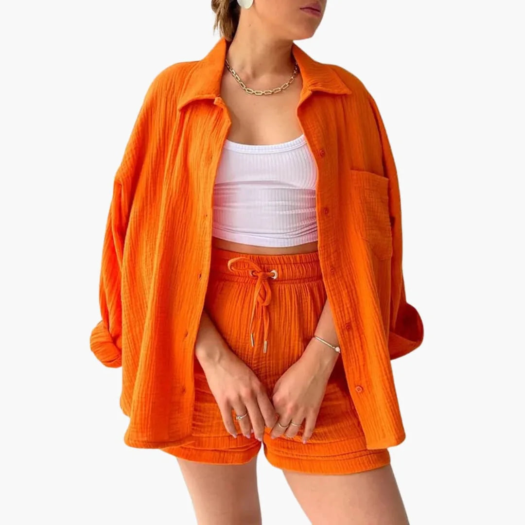 Model wearing an orange crinkle button-up shirt and matching shorts set