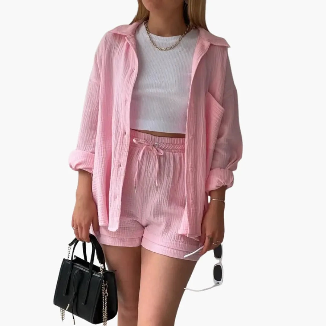 Model wearing a pale pink crinkle button-up shirt and matching shorts set