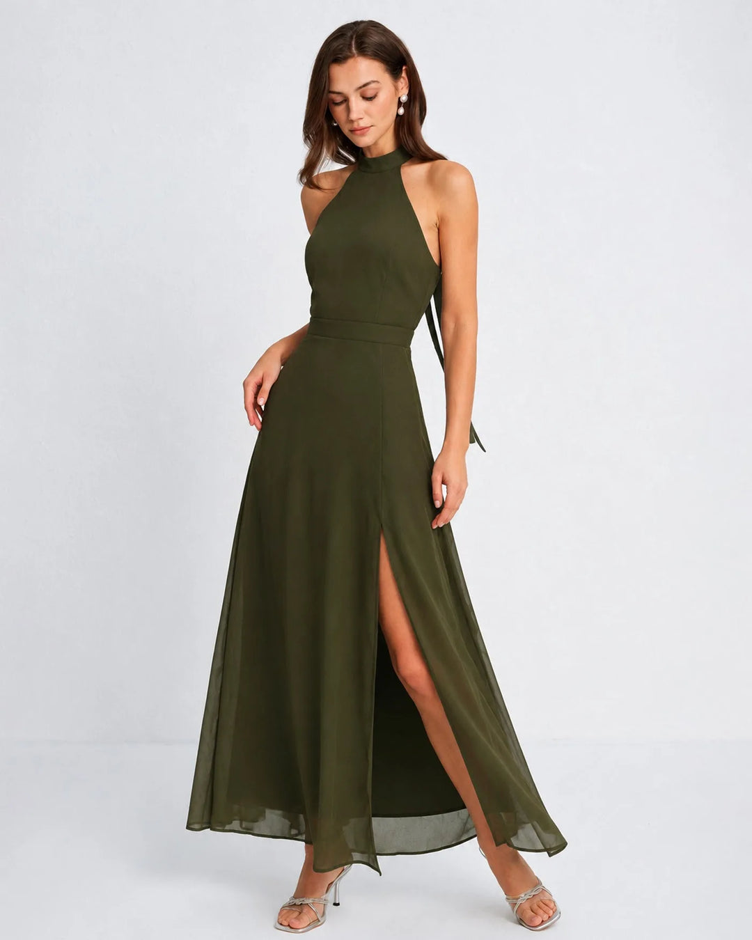 Woman in a floor-length green halter chiffon gown, facing forward