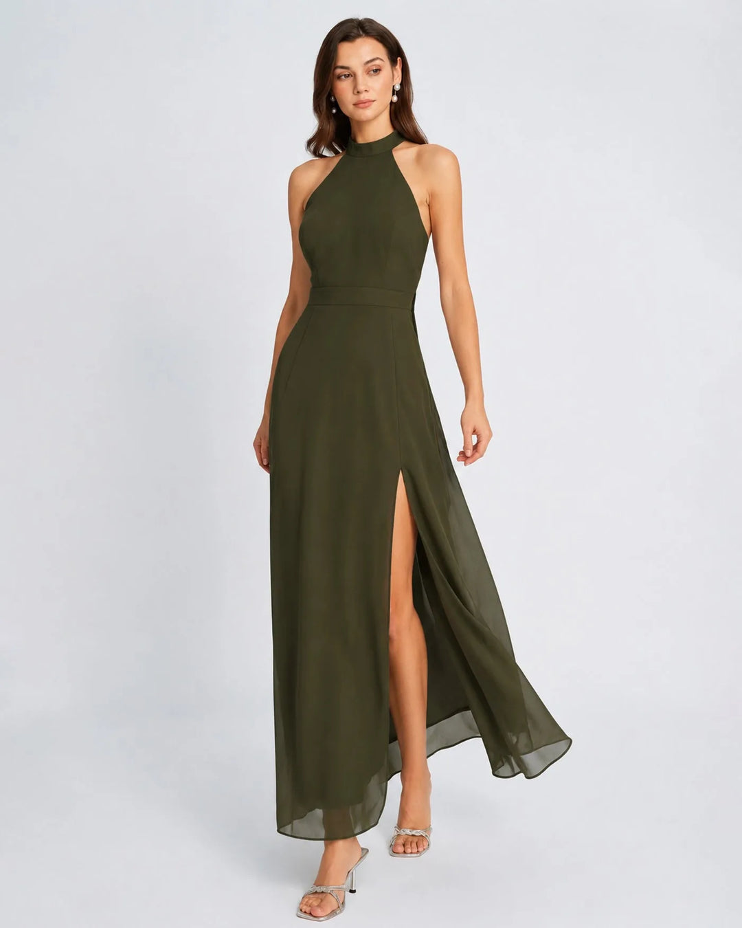 Woman in a floor-length green halter chiffon gown, turned three-quarters