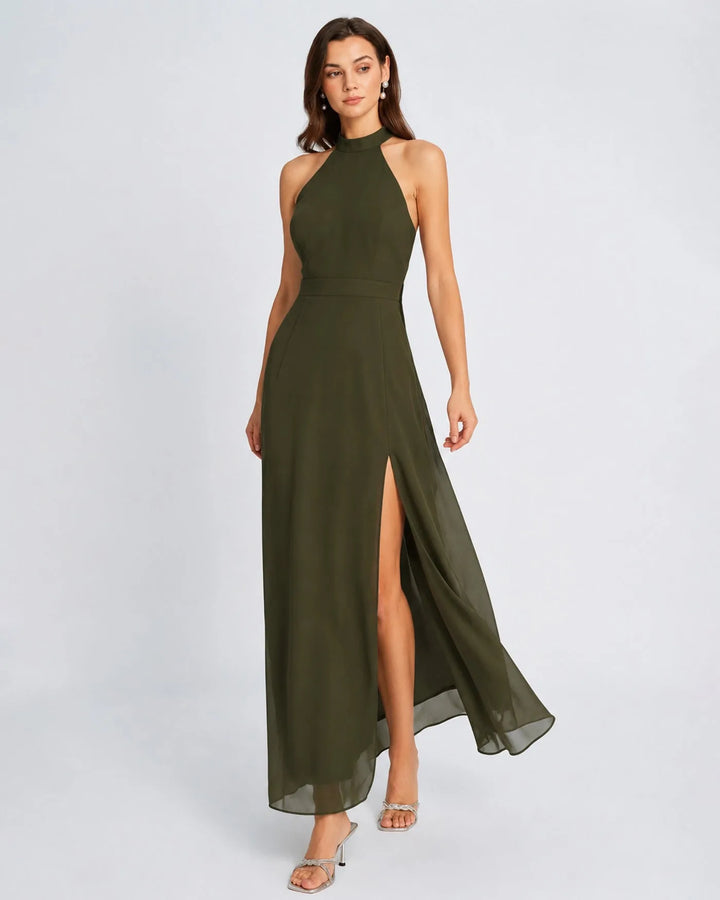 Woman in a floor-length green halter chiffon gown, turned three-quarters