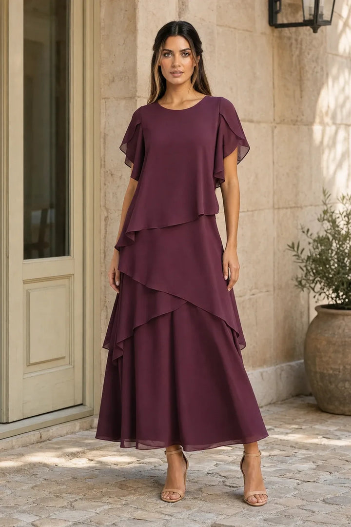 Brown tiered chiffon midi dress on a model in a contrapposto stance