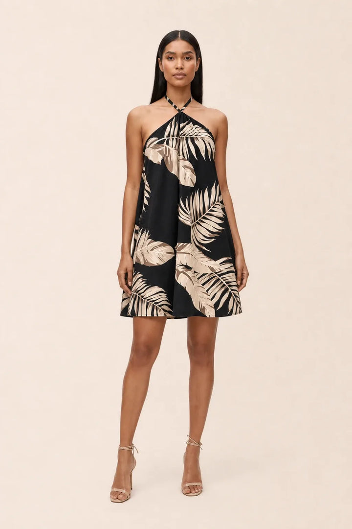 Model in black floral halter mini dress, standing in contrapposto pose