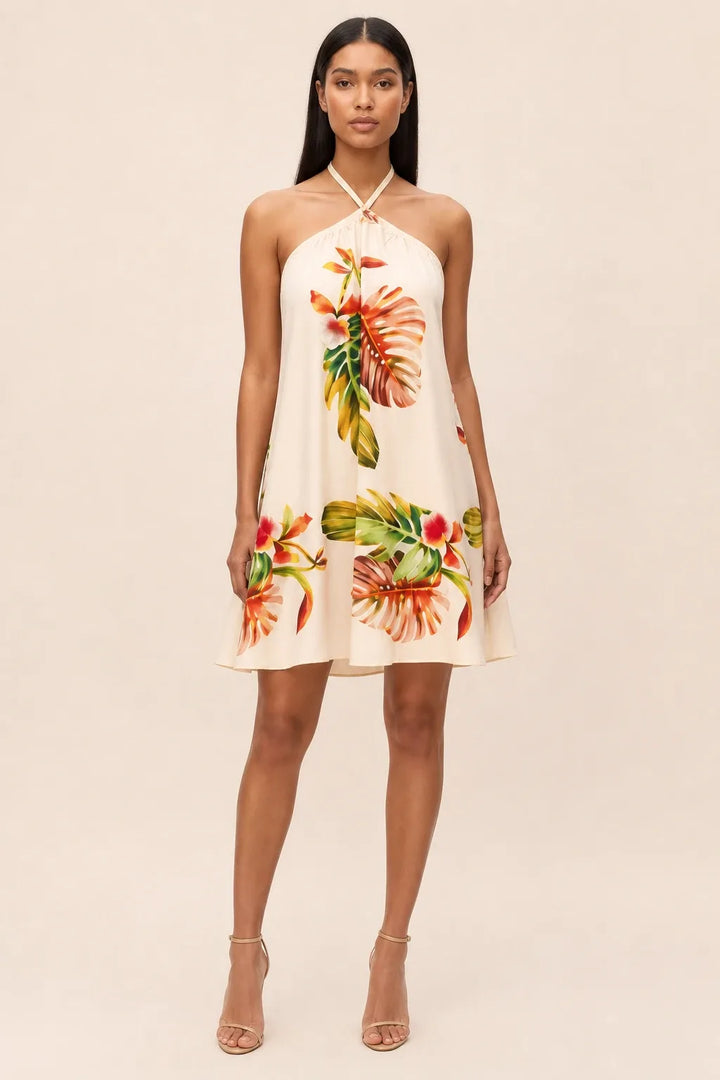 Model in orange floral halter mini dress, standing in contrapposto pose