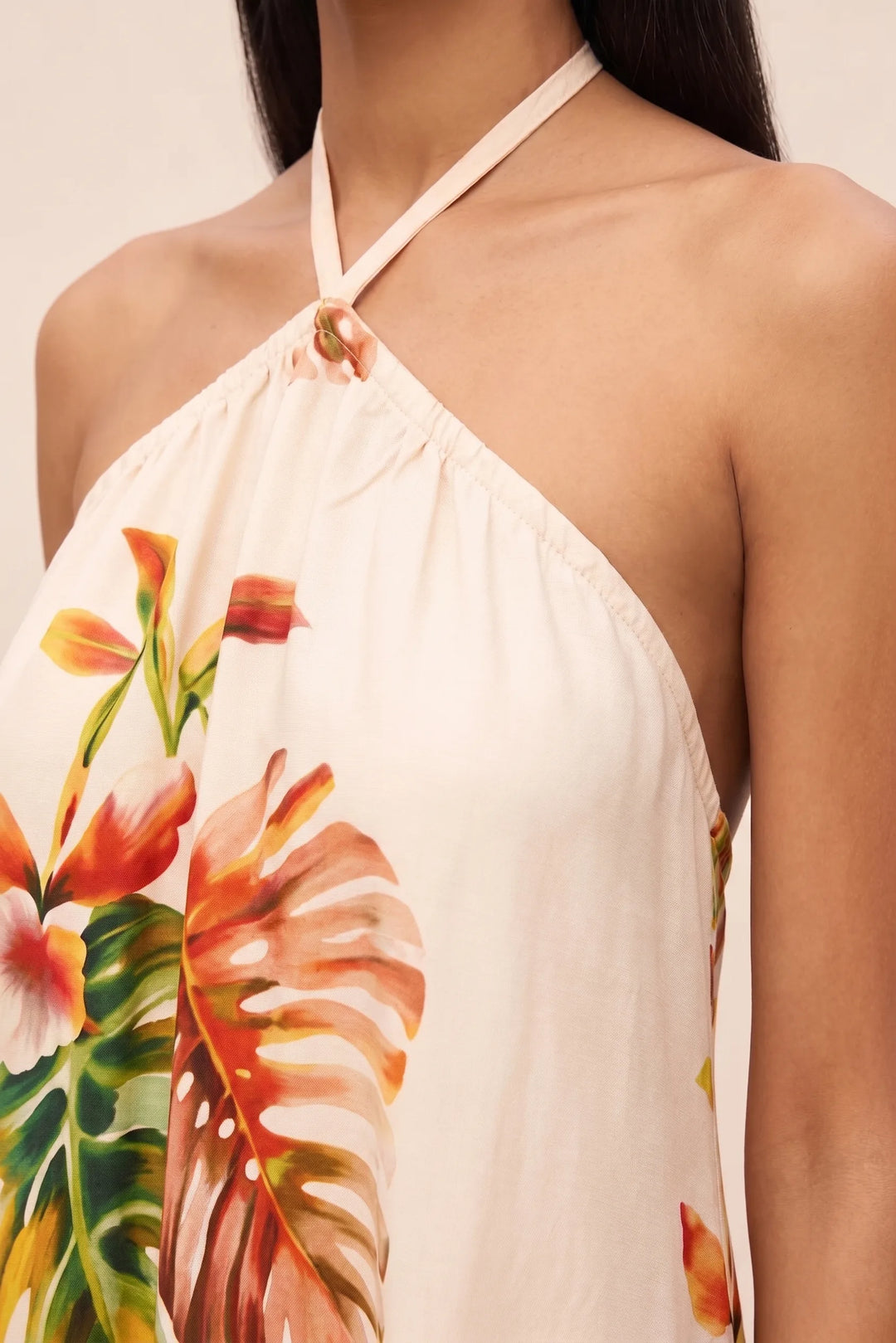 Close-up detail of orange floral halter mini dress fabric and design