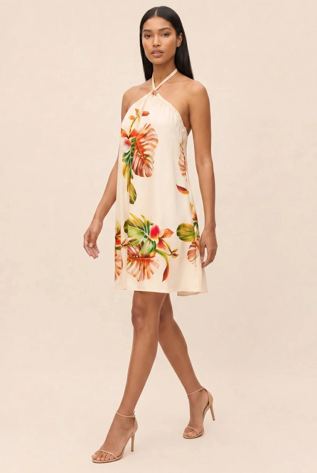 Model in orange floral halter mini dress, three-quarter turn view