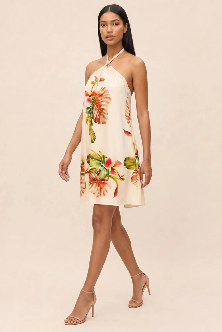 Model in orange floral halter mini dress, three-quarter turn view
