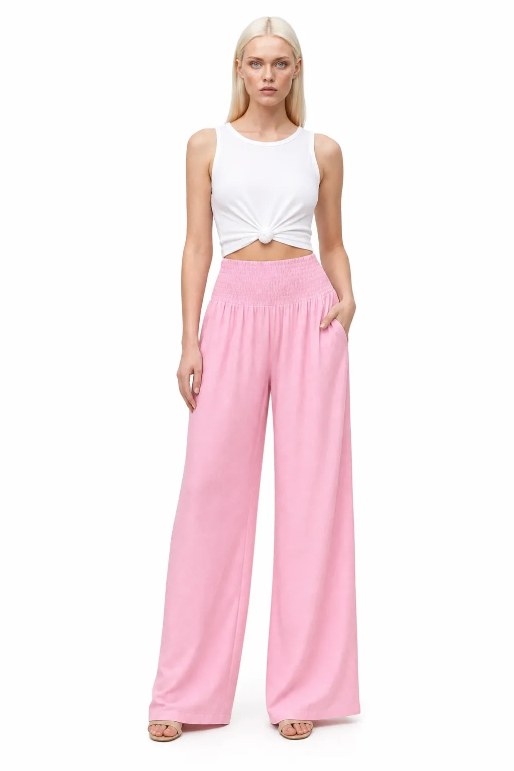 Pink smocked wide-leg pants on a model in a contrapposto stance