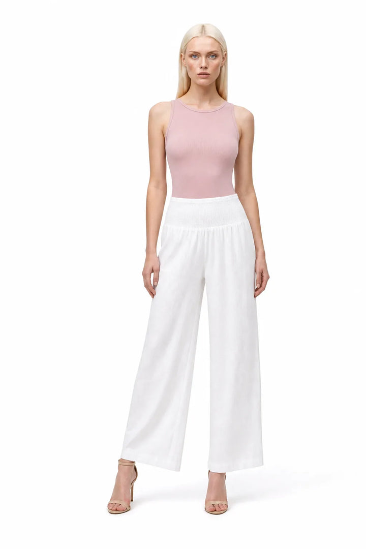 White smocked wide-leg pants on a model in a contrapposto stance