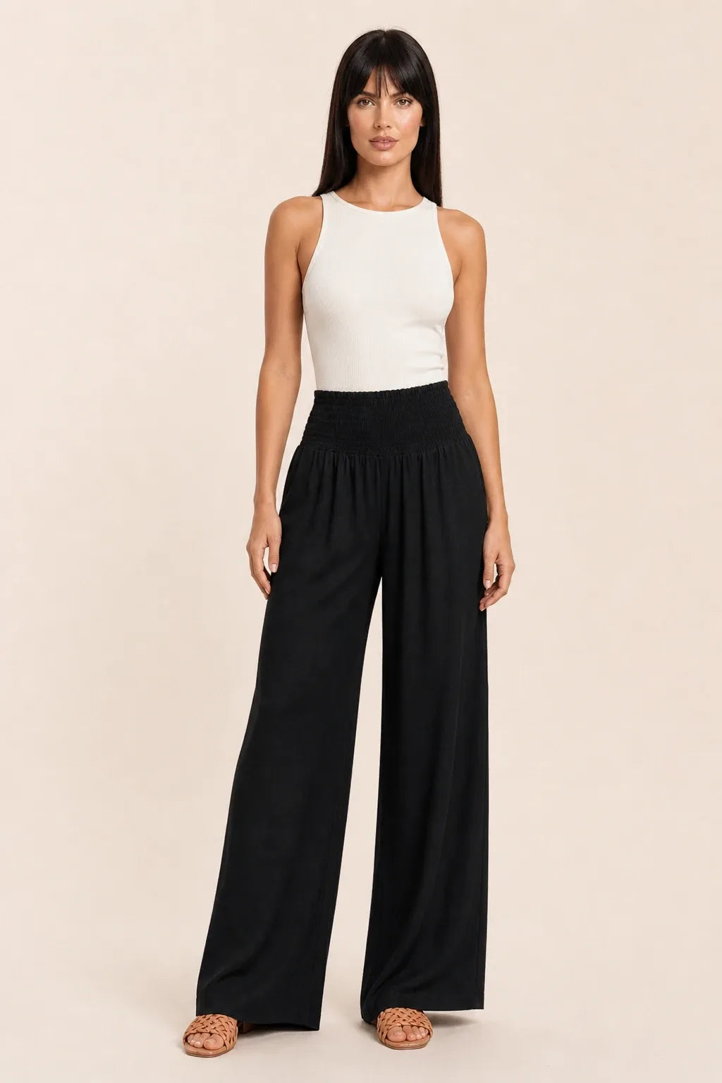 Black smocked wide leg pants on model in contrapposto stance