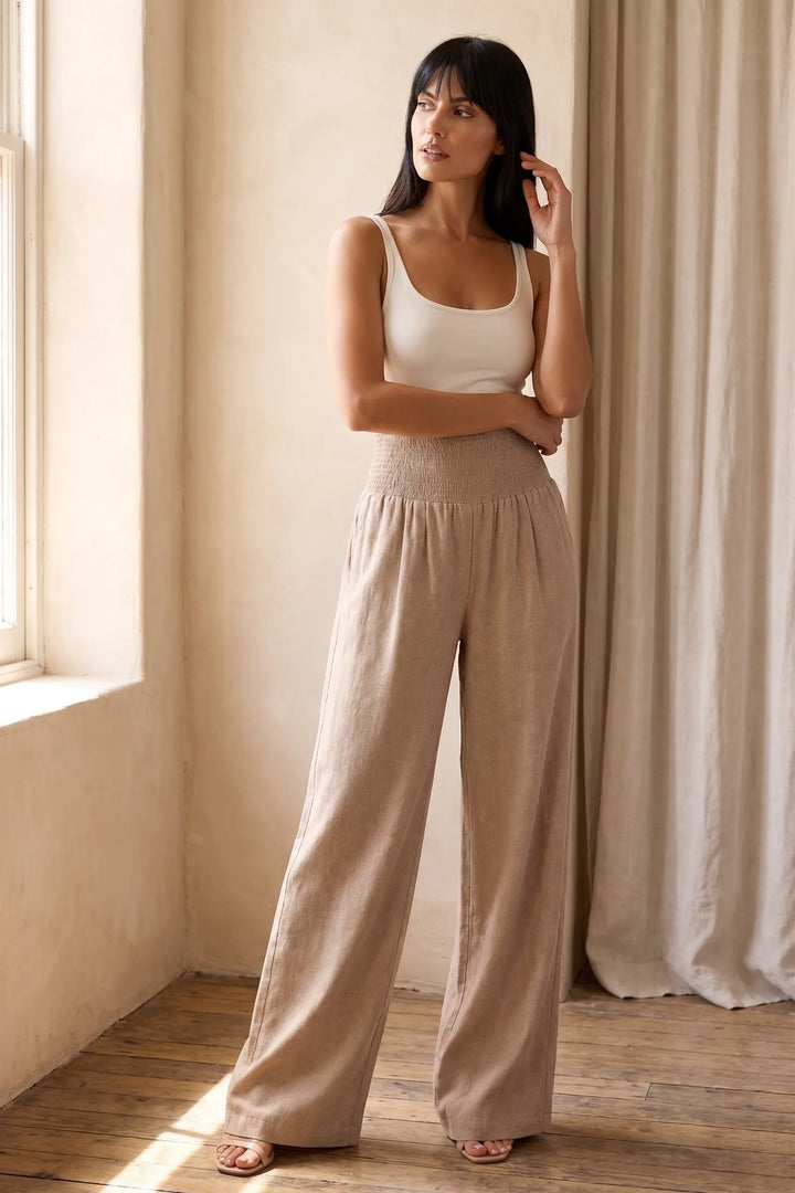 Model wearing khaki smocked wide leg pants in lifestyle setting