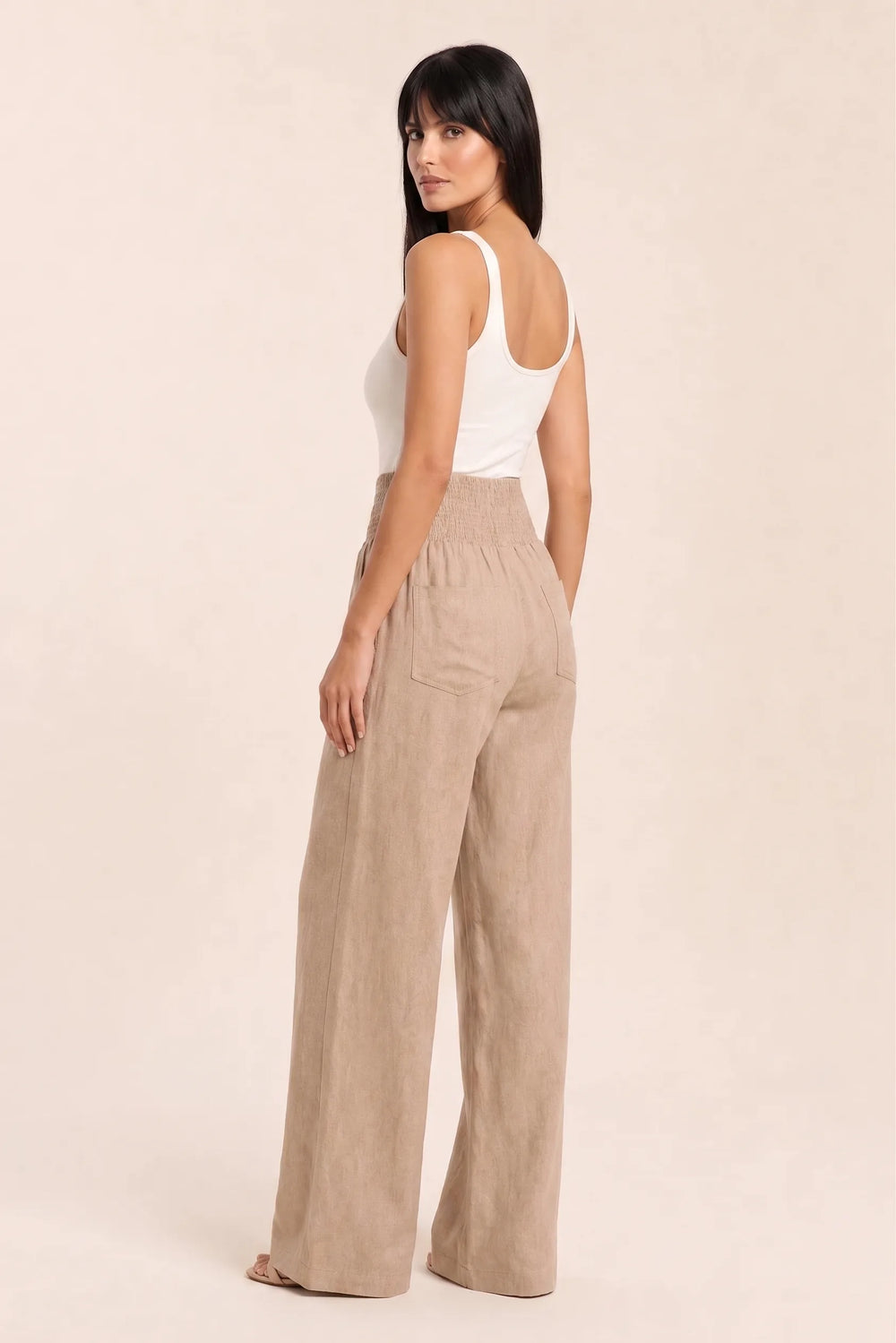 Khaki smocked wide leg pants on model in three-quarter turn