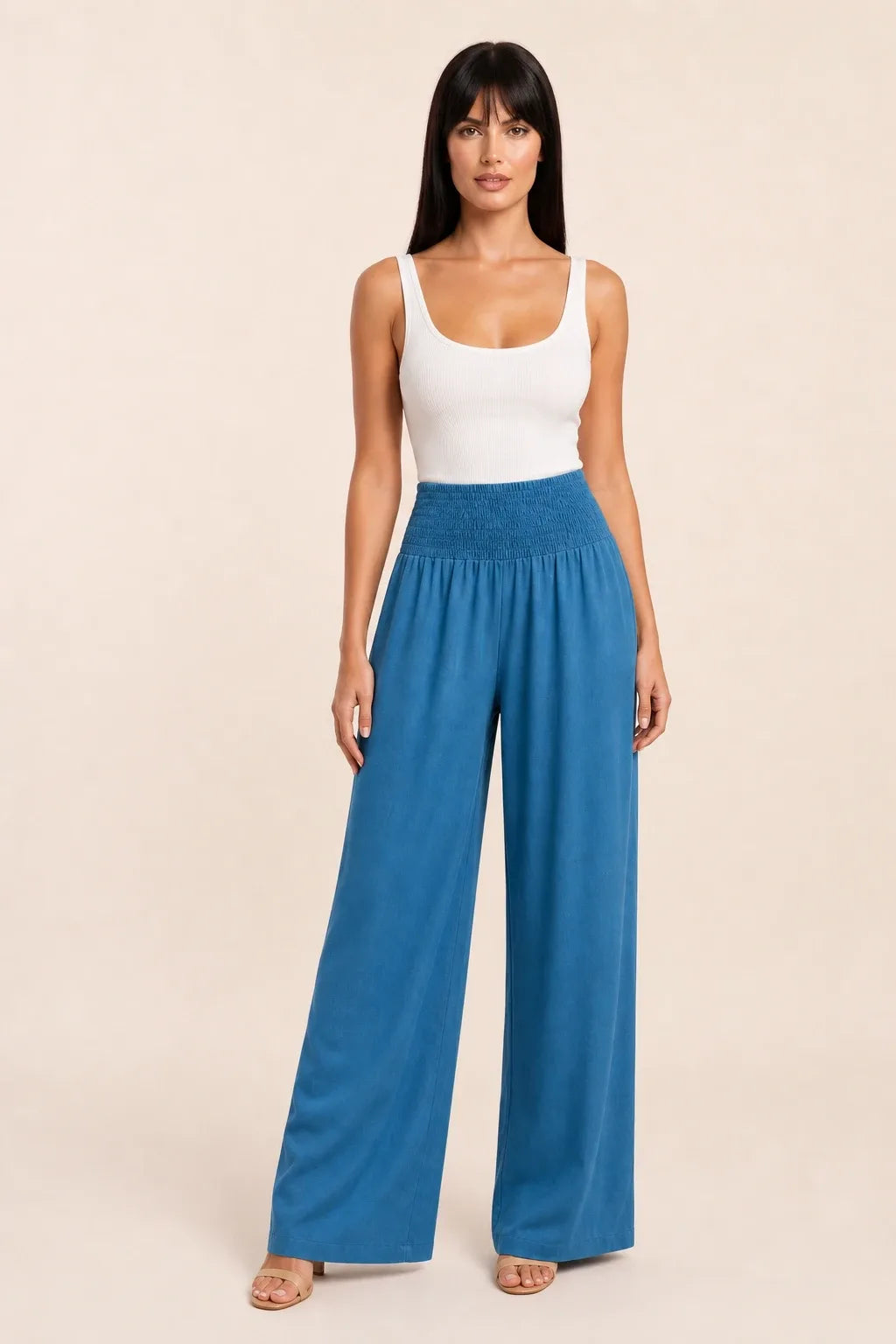Peacock blue smocked wide leg pants on model in contrapposto stance